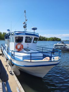 Kuvakollaasi, jossa hotelli, ihmisiä ryhmäkuvassa ja kesäisiä maisemia Pohjois-Karjalasta